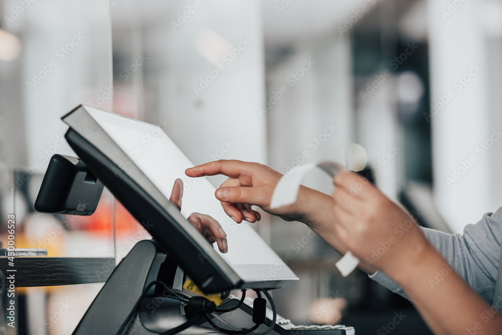 Hand am Touchscreen einer Kassa